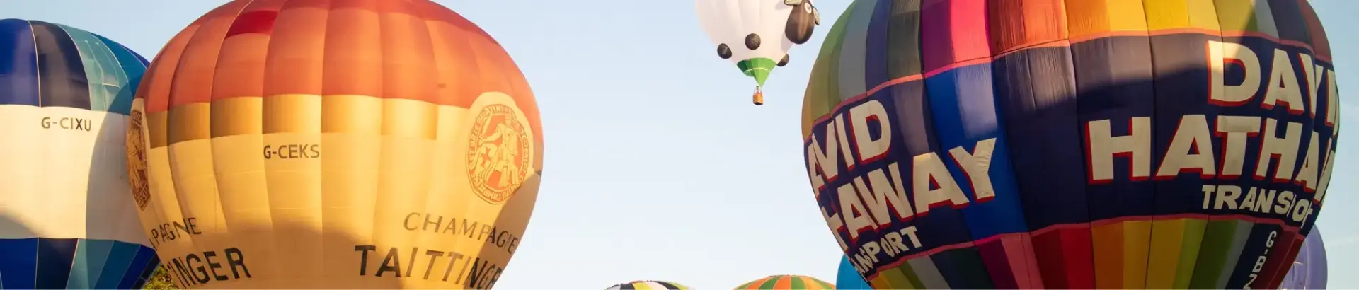 A group of hot air balloons in the process of taking off
