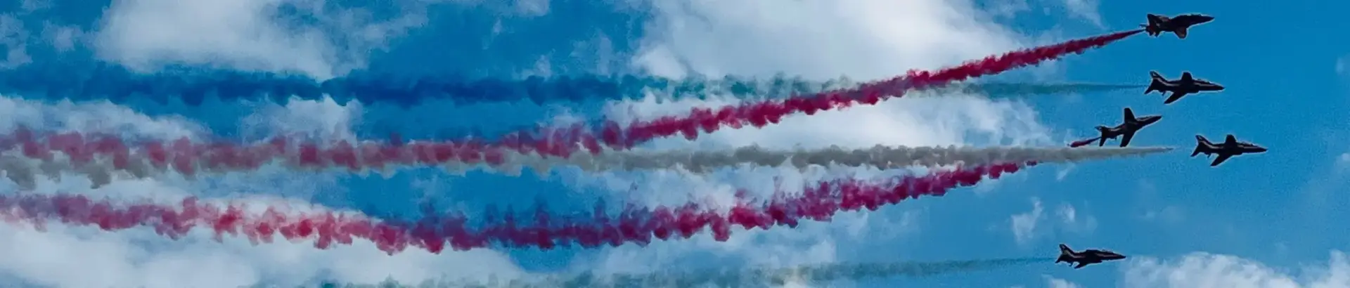 Display jet planes trailing coloured smoke in the sky